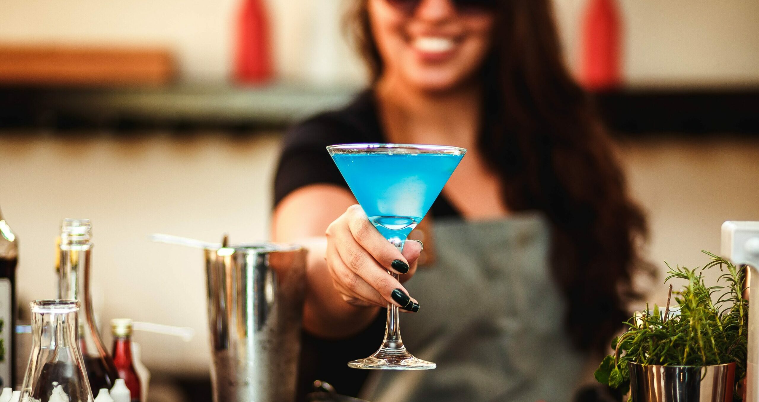 Bright blue non-alcoholic drink being served in a martini glass