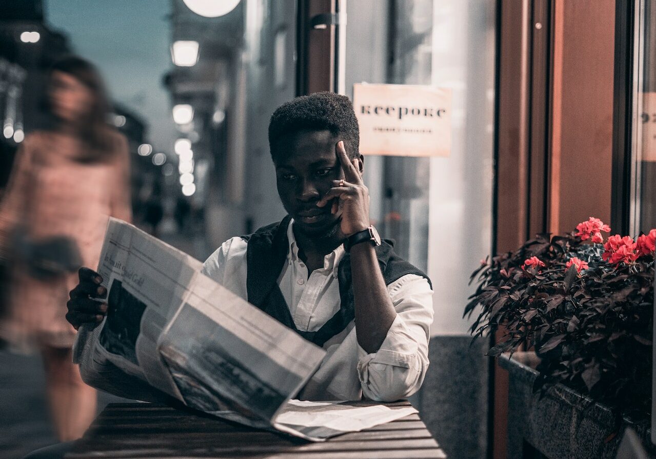 a man sits in a cafe reading the news